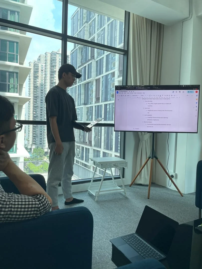 An office discussion with a presentation screen in 2023